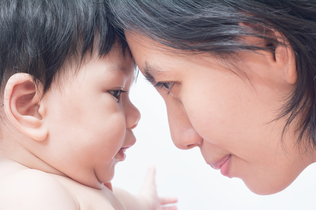 Asian mother and son stare each other to show their love for eac